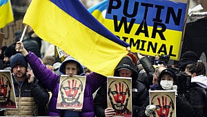 Pro-Ukraine demonstrators carry signs and Ukraine flags near Russia's UN Mission on Feb. 24, 2022 (AP Photo/Seth Wenig)
